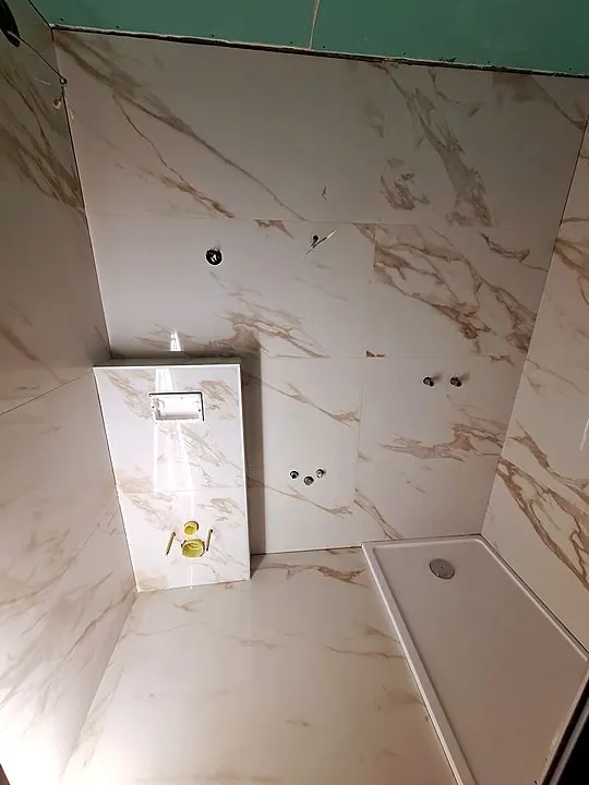 Mramor sa zlatnim žilama. Obloga instalacije i tuš kada.