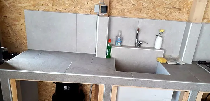 Zidana ljetna kuhinja. Radna ploča, sudoper i zid u istoj pločici.