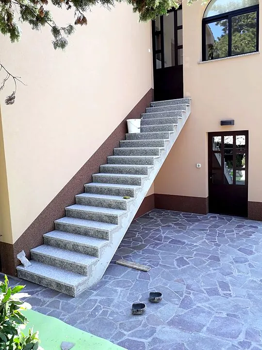 Granitno stubište. Uz dvorište popločano kamenim pločama.